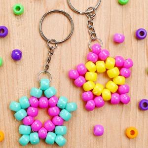 Photo of 2 keychains decorated with Kandi stars, made from pony beads; one in teal and pink, the other in pink and yellow.